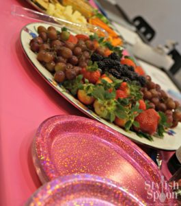 I made a few party platters - a Mediterranean platter with hummus, veggies and olives and a fruit platter for the girls and grownups to snack on. I made the party platters on Mackenzie Childs courtly check enamel platters and wrapped them in plastic wrap to transport to the salon. I also set out a bowl of tortilla chips, and used hot pink glitter paper plates that I found at Target (Spritz brand). I bought the plates in two different sizes (dinner and desert plates) and coordinating hot pink luncheon napkins.